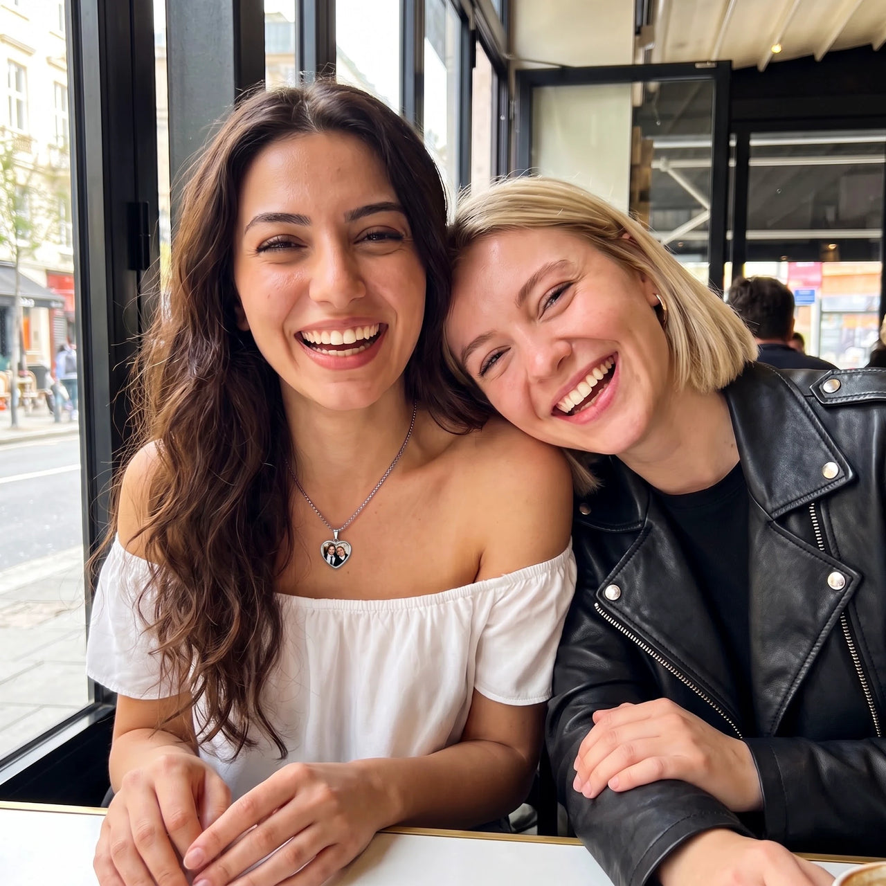 Two best friends laughing together, one wearing the silver secret heart photo necklace | SKU: TPH-CHTN-SILVER-SMALL