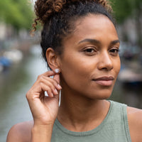 Thumbnail for Woman gently touching her silver stud earrings | SKU: 1953493